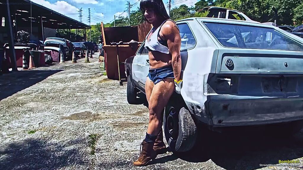 Bombshell lifting car in a scrapyard - muscular woman strength video